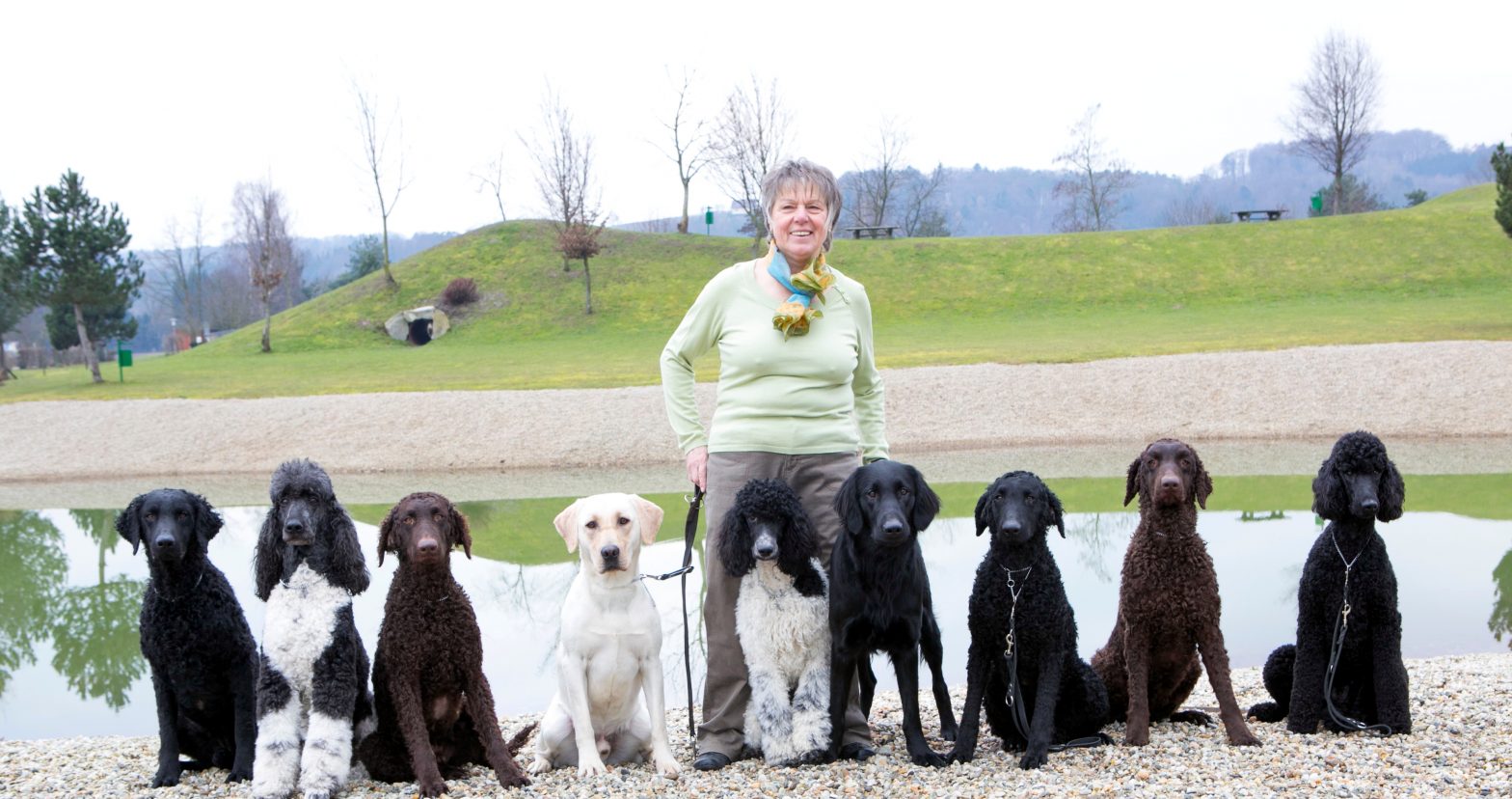 Trainer Maria Gerstmann with 9 sitting trainees by a lake